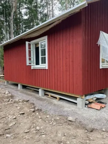 Röd stuga på plintar - byggnationer